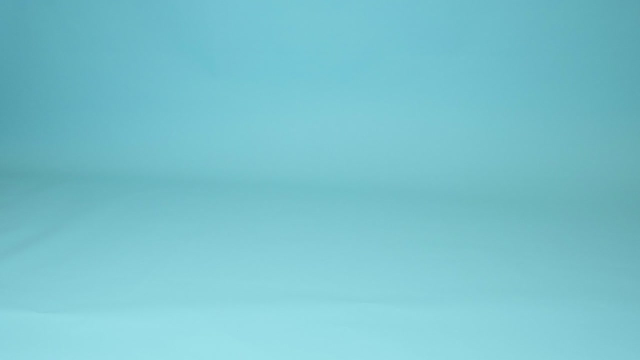A child toy ball bounces on the floor on a studio blue background