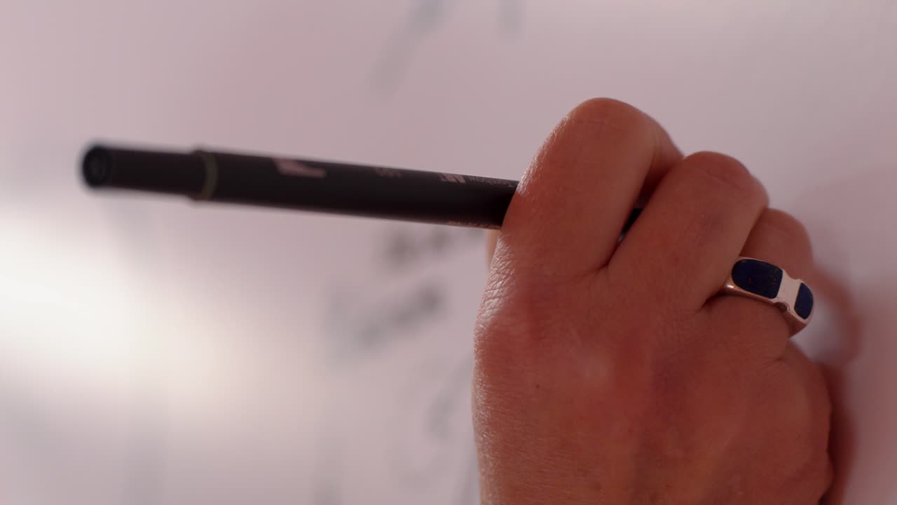 close-up shot of a hand writing on a whiteboard during a presentation