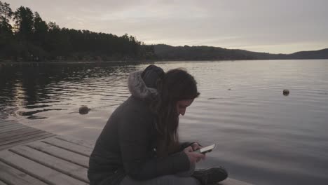 mujer sentada junto al lago