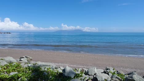 scenic landscape view tropical blue ocean water and sandy beach on a sunny day in the capital dili overlooking popular tourism diving destination of atauro island in timor-leste