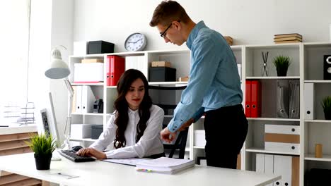 director giving new work to employee working at computer