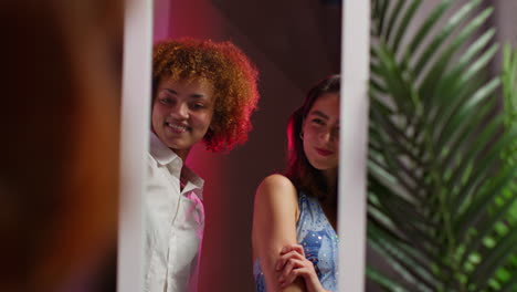 two friends posing in a stylish room with a mirror