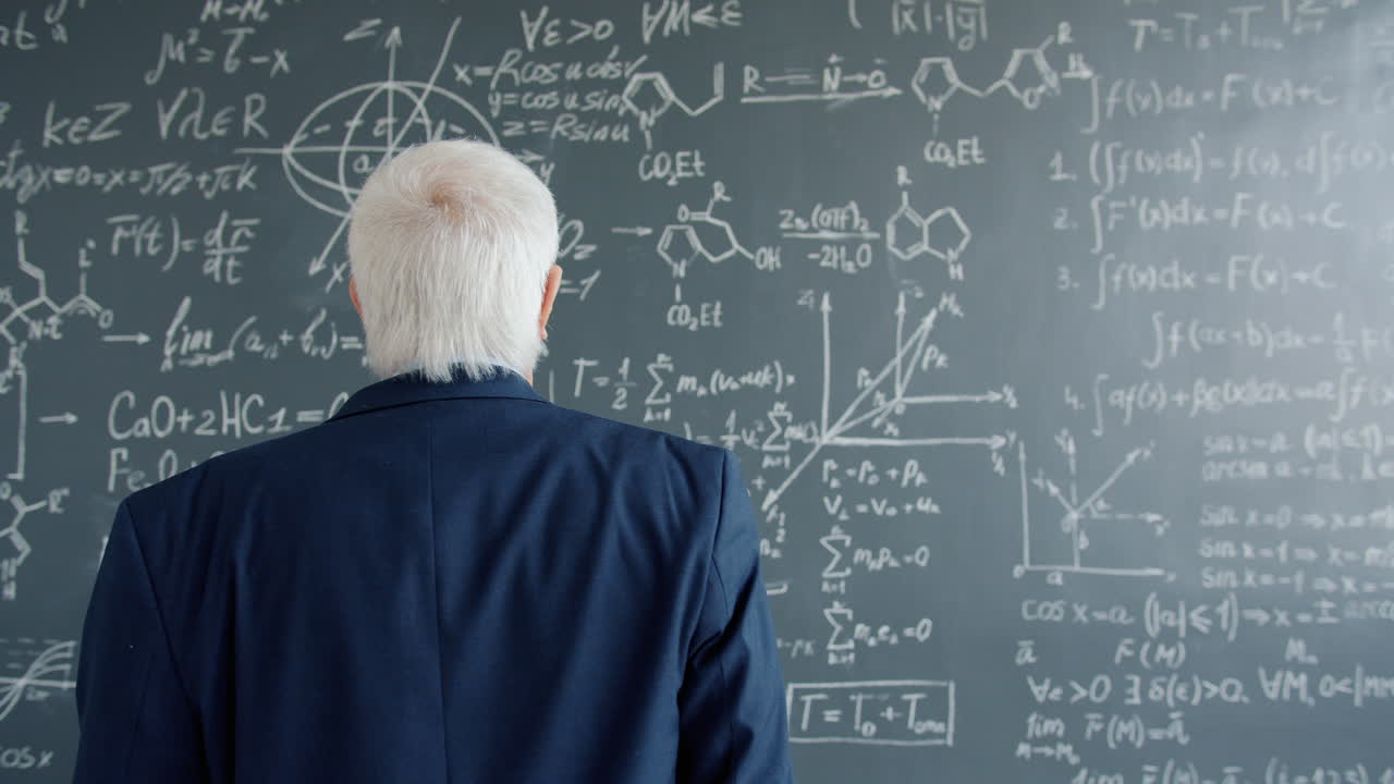 Professor looking at math equations on a chalkboard