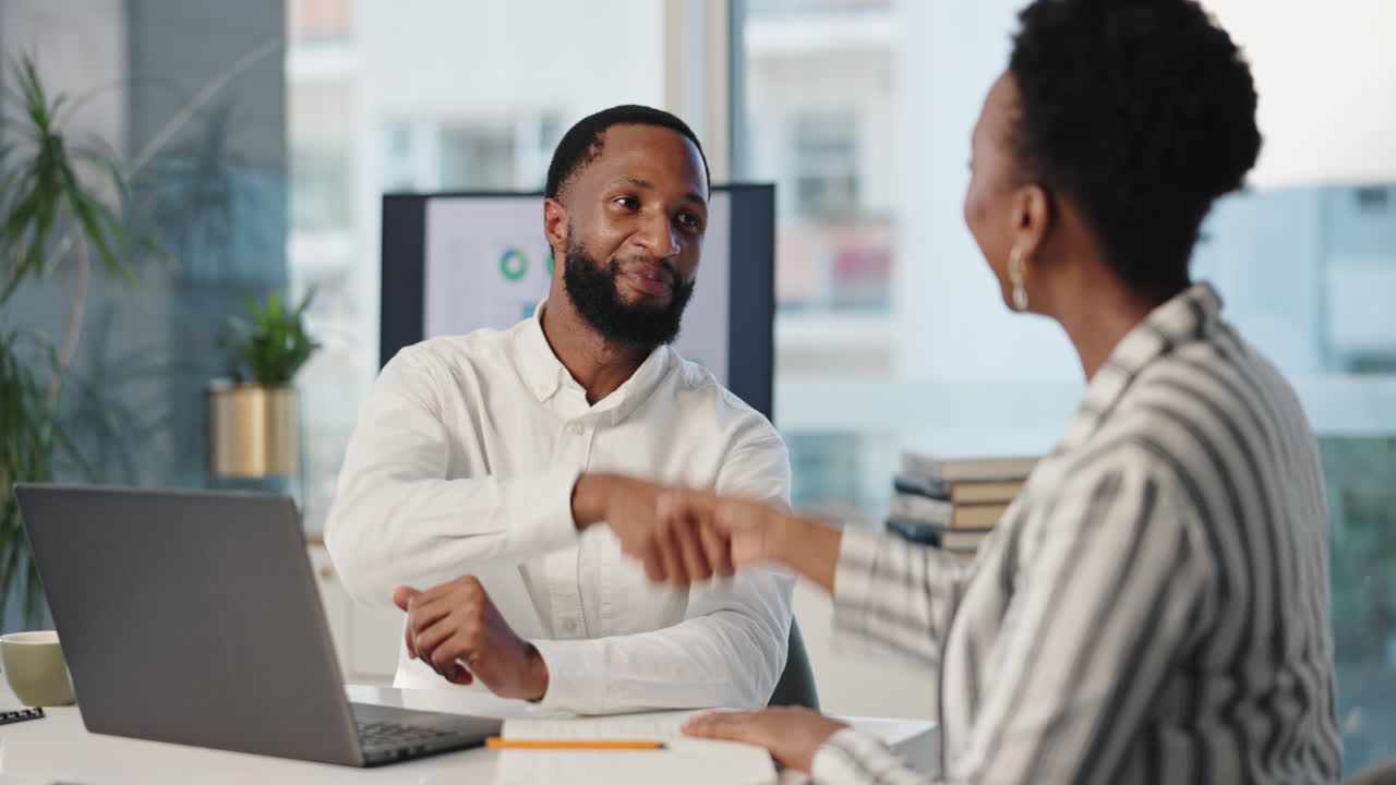 Business handshake between colleagues in office setting