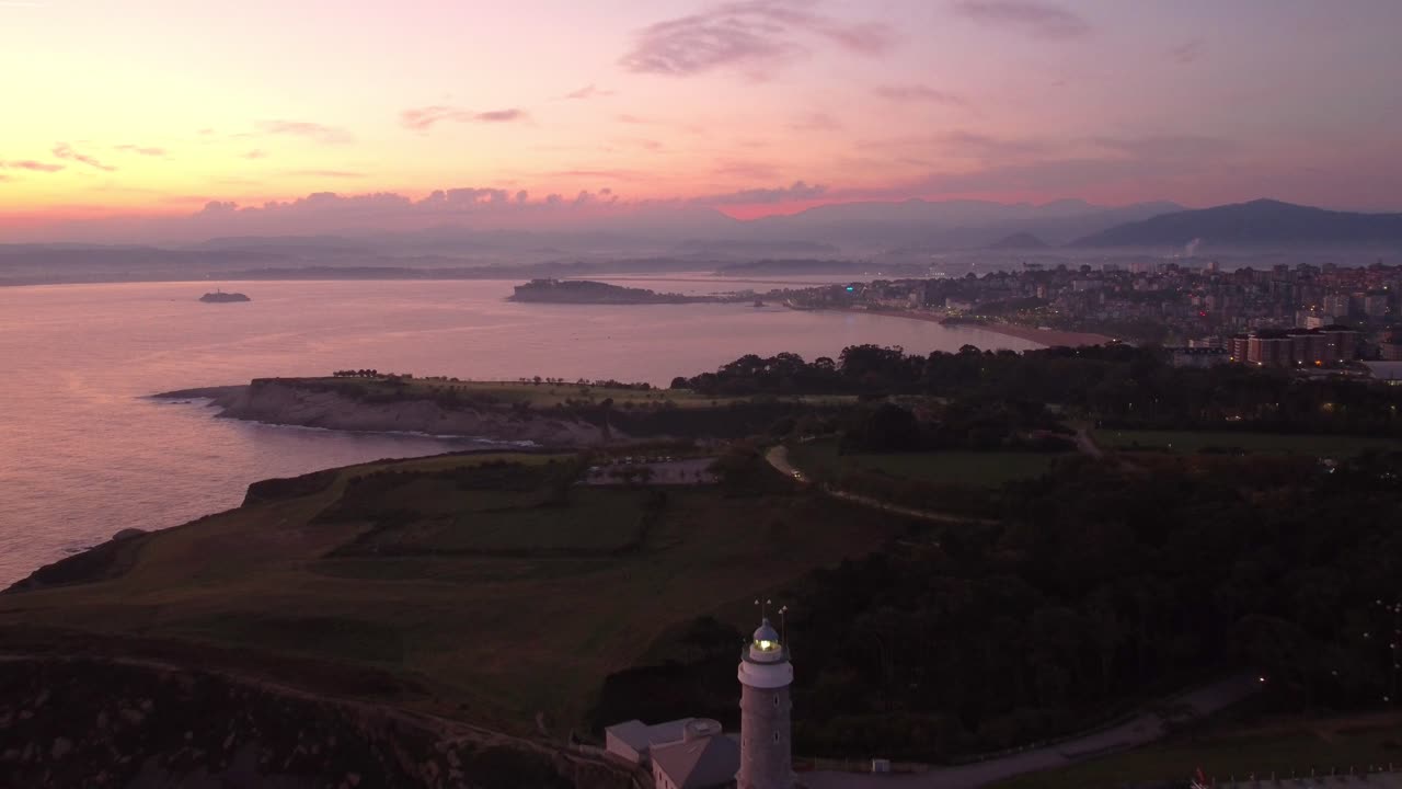 Veduta aerea con drone al tramonto della città di Santander, Spagna, con costa settentrionale e vista sull'oceano, sorvolando la scogliera