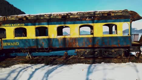 4k drone video of abandoned alaska railroad train car on seward, alaska beach on snowy winter day