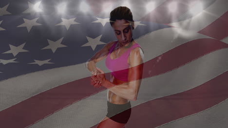 Die-Amerikanische-Flagge-Schwenkt-über-Einer-Sportlerin,-Die-Im-Hintergrund-Ihren-Bizeps-Vor-Dem-Sportstadion-Beugt