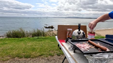 preparando comida en una parrilla junto al mar