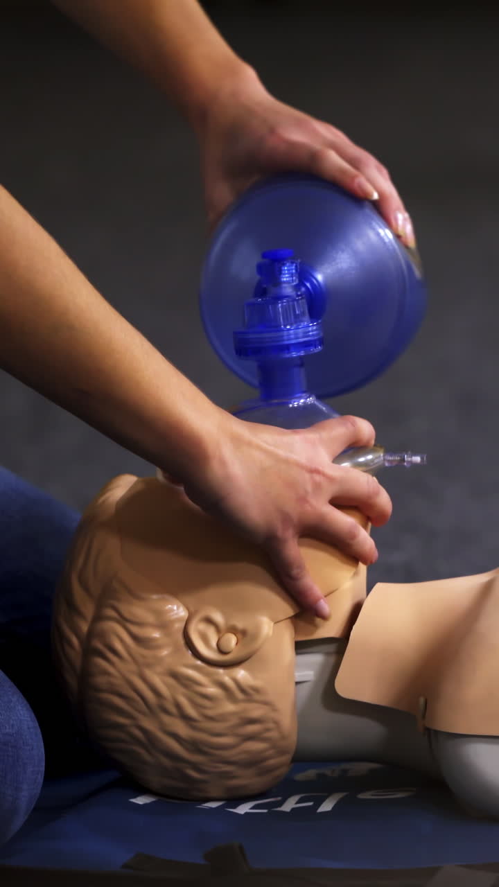 Resuscitation during first aid training. First aid instructor showing resuscitation technique on dummy. Vertical video