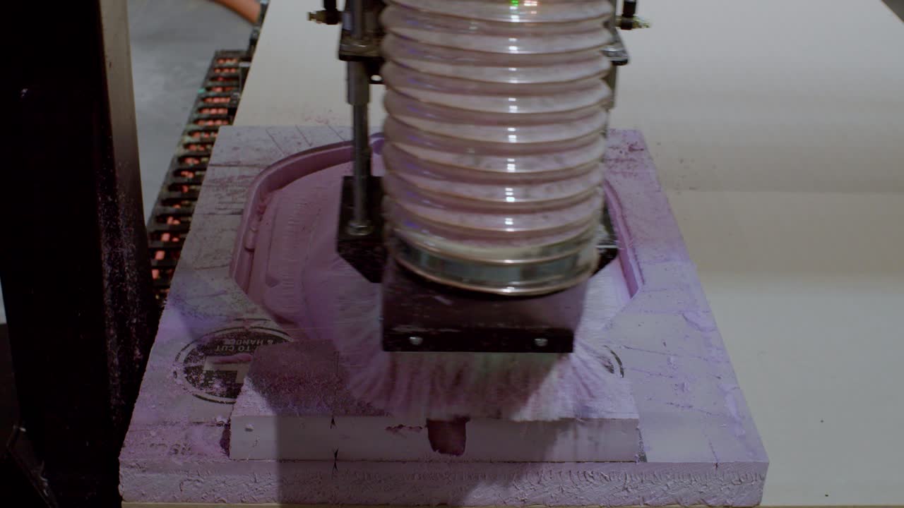 CNC machine carving a 3D mask on foam