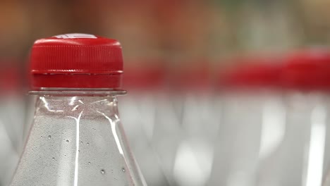 close-up of a plastic bottle with a red cap and condensation