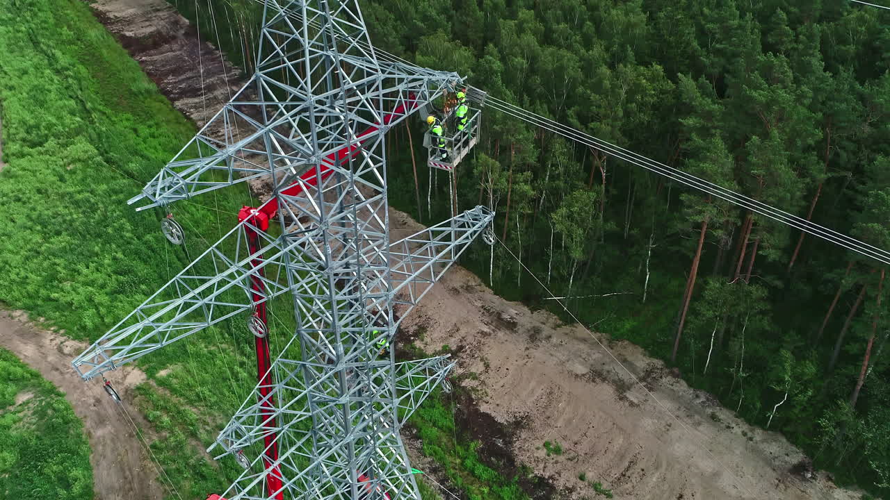Workers on high voltage pylon and surrounding landscape
