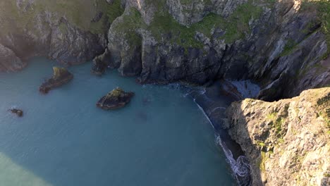 Drone-Pequeña-Playa-Escondida-Bajo-Acantilados-Costa-De-Cobre-Waterford-Irlanda-En-La-Hora-Dorada