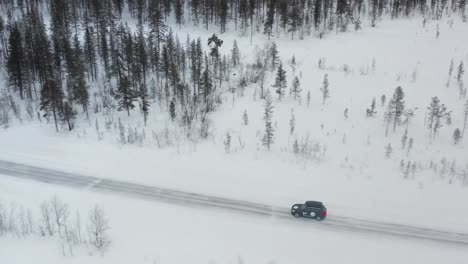 car driving on a road covered with snow and ice through the countryside of finland