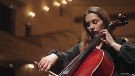 female cello player is rehearsing in music hall beautiful violoncellist with violoncello on scene