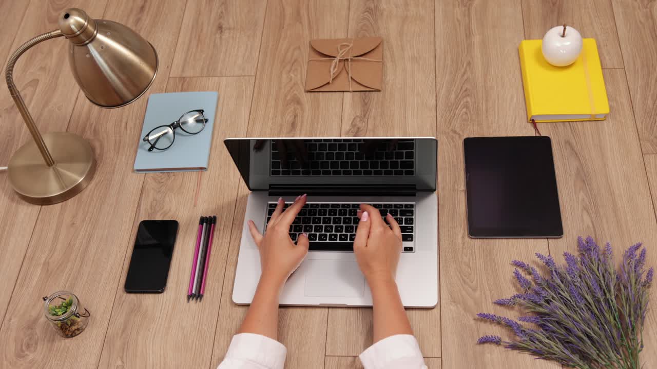 espacio de trabajo con computadora portátil, manos de la niña, cuaderno sobre fondo de madera.