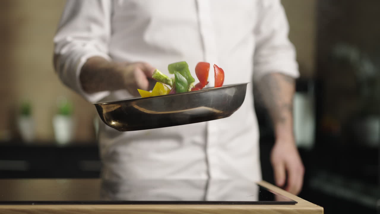 Chef tossing vegetables in a frying pan