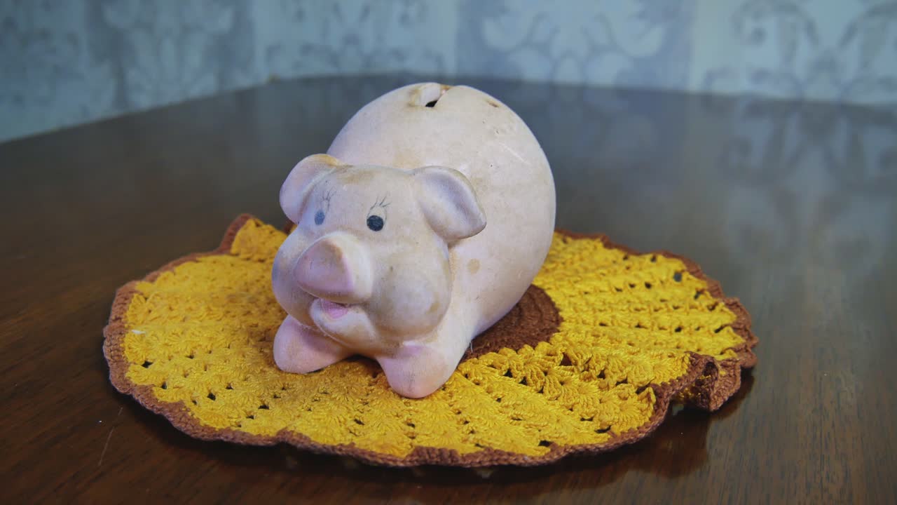 Staré špinavé prasátko na háčkované žluté ubrousku.