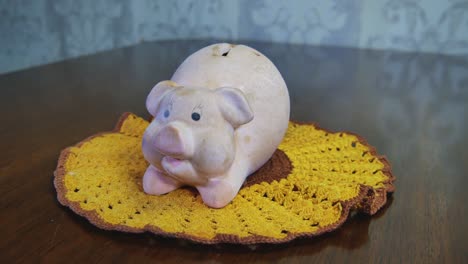 old dirty pig piggy money saver bank on crocheted yellow napkin