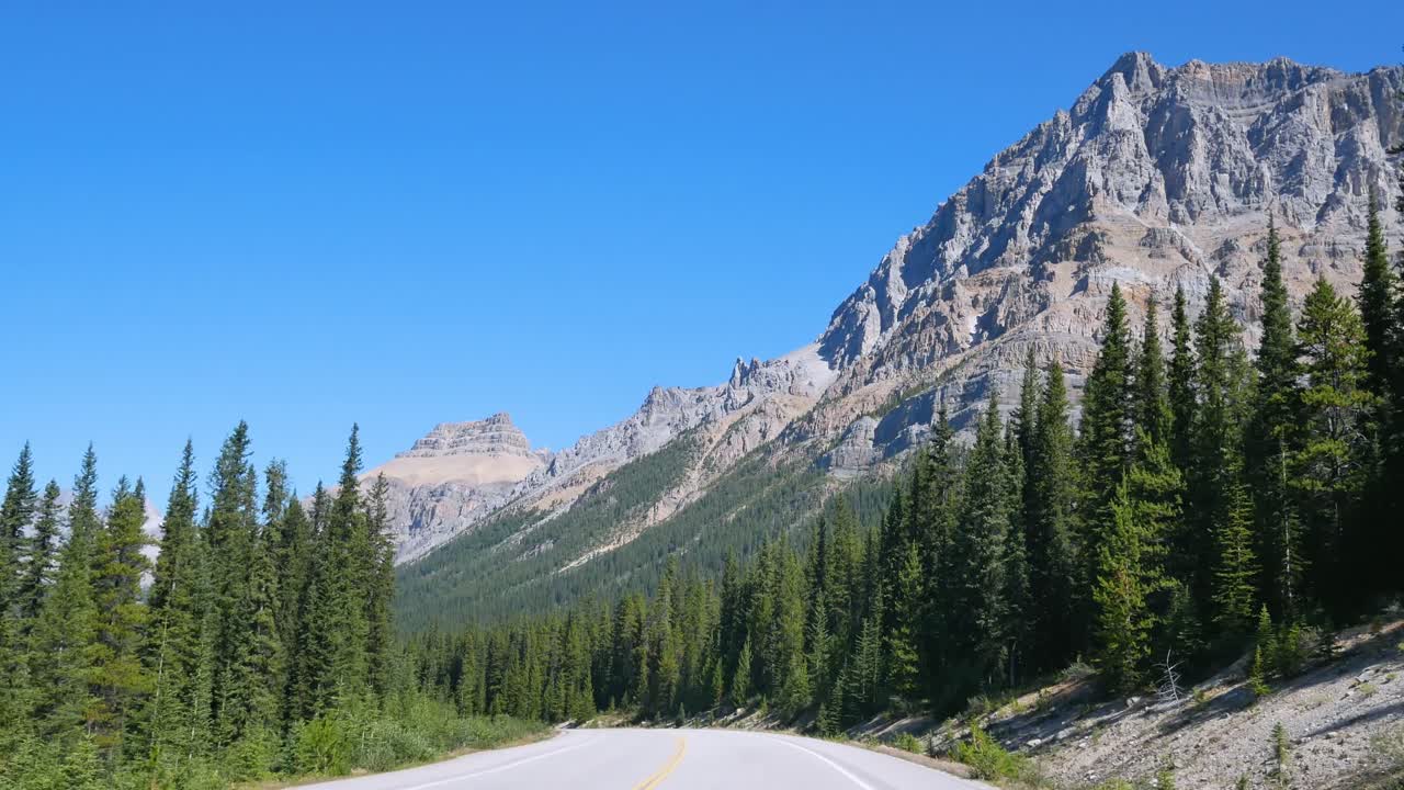 vista desde la parte delantera del automóvil mientras se mueve a lo largo de las avenidas del campo de hielo en el parque nacional de banff, canadá