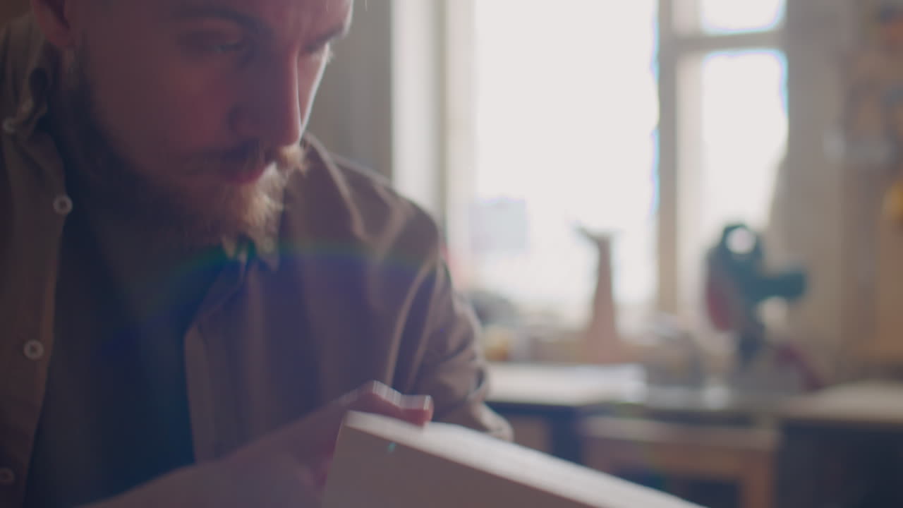 Carpenter Using Set Square and Pencil for Measuring Wooden Plank