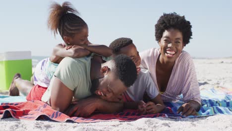 Video-Einer-Glücklichen-Afroamerikanischen-Familie,-Die-Am-Strand-Liegt-Und-Lacht