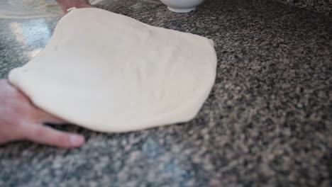 thin and round shaped pizza dough prepared by the italian chef