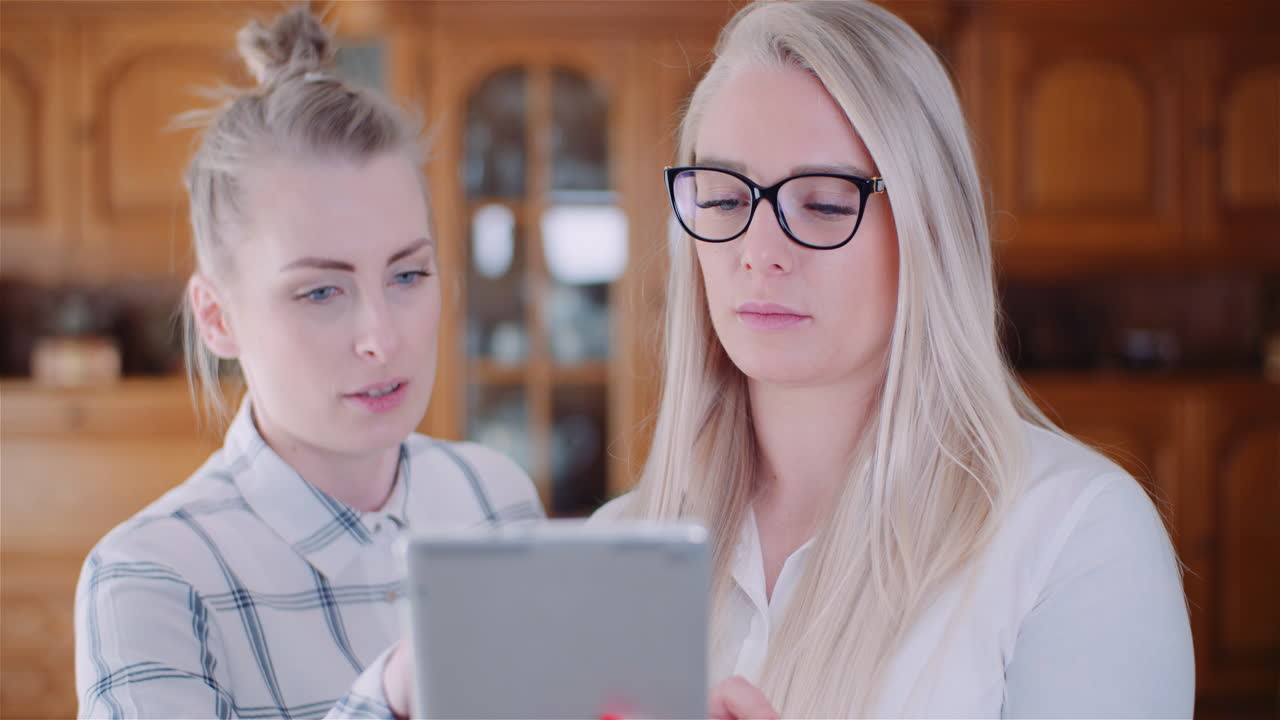 compañeras de trabajo discutiendo sobre una tableta digital en la oficina 1