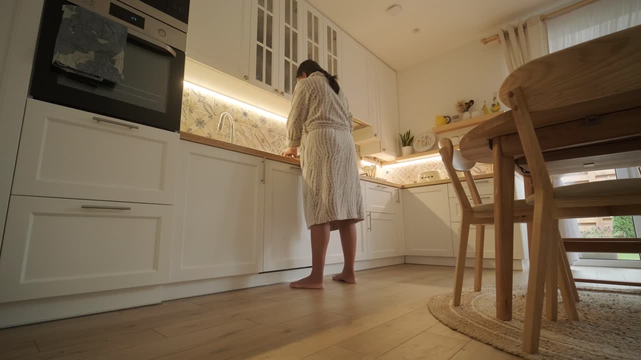 Una donna incinta che si gode la sua routine quotidiana a casa, rilassandosi in salotto e mangiando in cucina. La scena evidenzia comfort, maternità e momenti di cura di sé in un ambiente accogliente