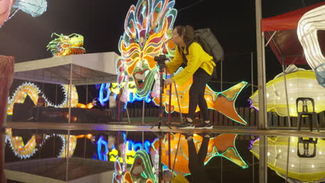 a woman with camera monopod at the park with colorful light display