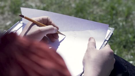 person sketching outdoors