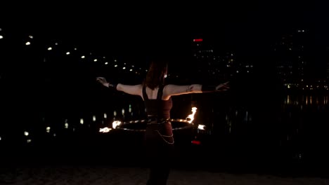 redhead firegirl twisting fire hula hoop by river