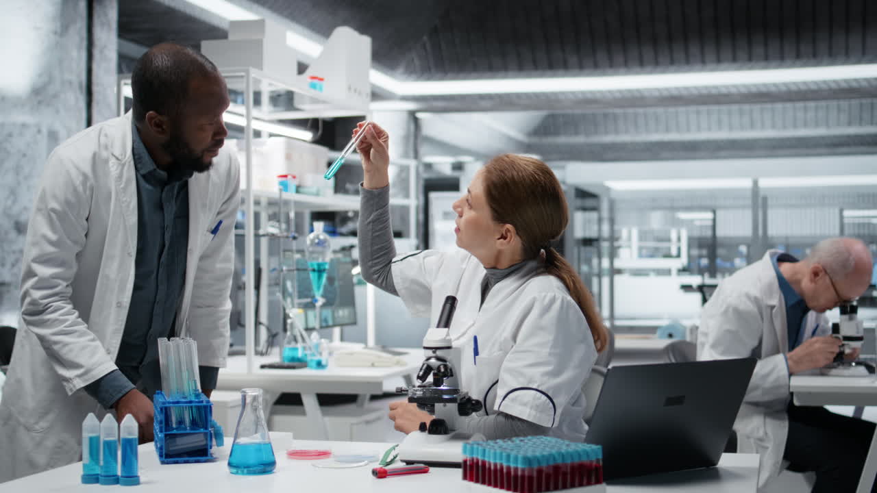 Lab researchers inspect liquids in glass flasks during clinical trials