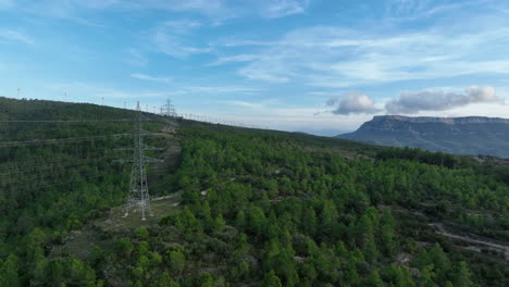 Hochspannungsmasten-Mit-Windpark-Im-Hintergrund,-Trucafort,-Pradell-De-La-Teixeta,-Tarragona-In-Spanien