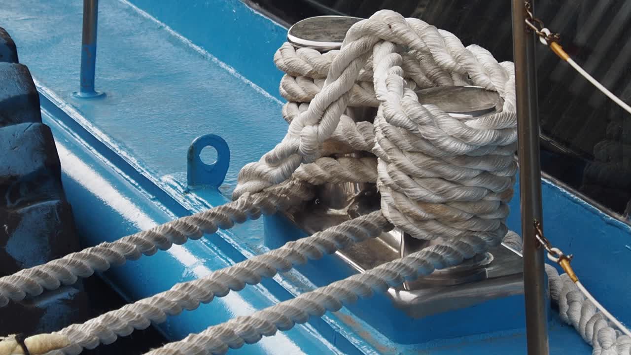 primer plano de las cuerdas de amarre atadas a los cleats en un barco azul