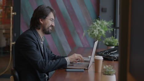 hombre de negocios trabajando en una computadora portátil en un café