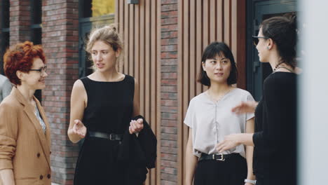 young diverse businesswomen having discussion on city street