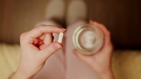 woman taking a pill with water