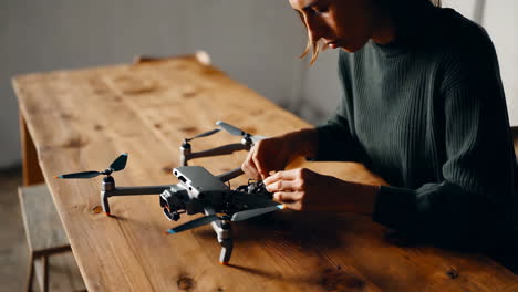 woman repairing a drone on a wooden table