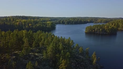 aerial shot epic shot of a nordic forest in finland, national park with islands and forest, stone shores and deep blue water