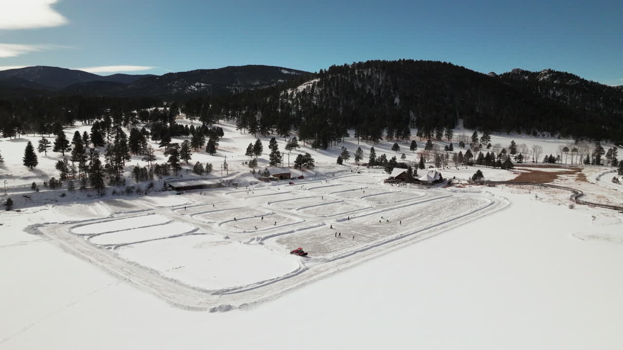 patinaje sobre hielo patinaje hockey pista de hockey lago estanque hockey invierno etown casa de lago siempre verde campo de golf de denver colorado drone cinematográfico aéreo soleado mañana azulado invierno nieve fresca círculo de movimiento a la izquierda