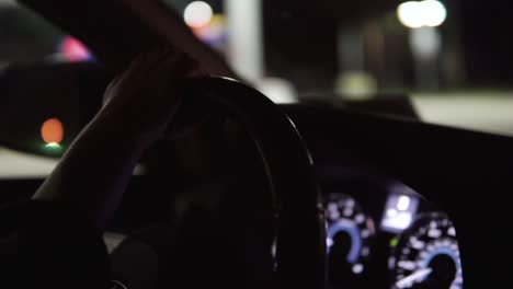 driver holding steering wheel while driving at night