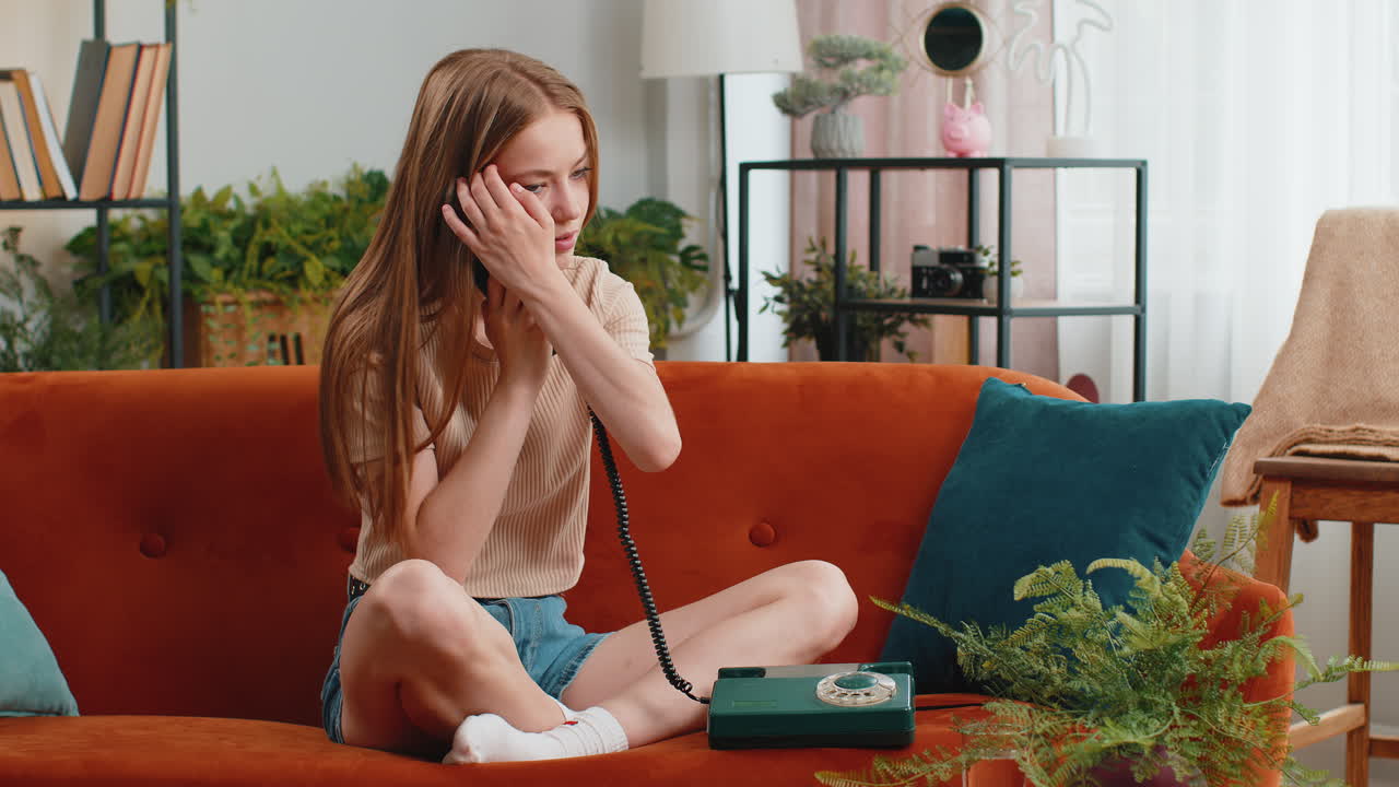 Woman making wired old-fashioned retro vintage telephone talking conversation with friends at home