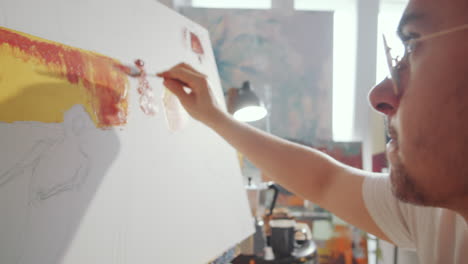 artist using palette knife while painting on canvas