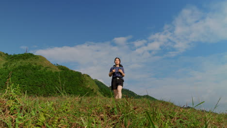 low angle slow motion young female solo backpacker traveller walking alone on mountains path contemplate the viewpoint