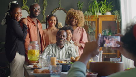joyous large family posing for photo at home dinner