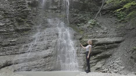 mujer tomando una selfie frente a una cascada