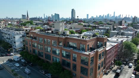 Aerial-view-of-modern-buildings-with-rooftop-terrace-in-Greenpoint-district-in-Brooklyn,-New-York---beautiful-sunny-day-with-skyscraper-buildings-in-backdrop