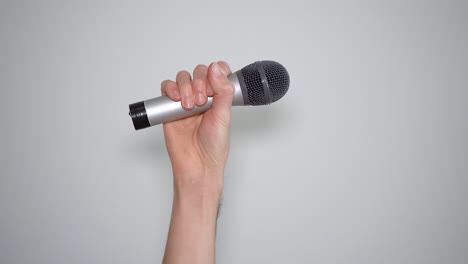 Man's-hand-raising-a-microphone