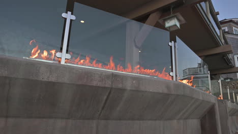 calentador de fuego al aire libre - pozo de fuego de mesa detrás de un protector de vidrio en el patio de la casa